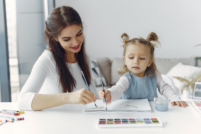 mom teaching her daughter how to paint